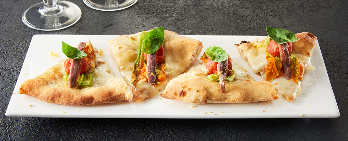 Pizza gourmet con fiori di zucca, acciughe del canabrico, minired e buccia di limone