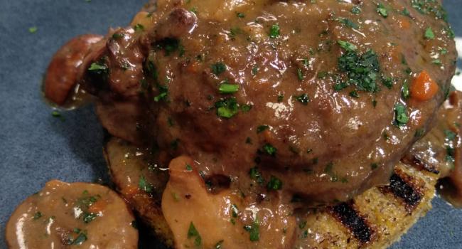 Braised pork cheek with sangiovese, mushrooms, served with rosemary  rustic polenta