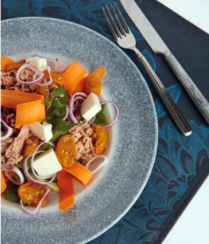 Ensalada de atún con tomates dátil amarillos, cebollas cortadas en rodajas y mozzarella
