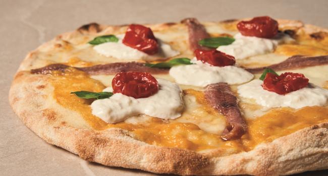 Pizza con passata gialla, acciughe e dorati