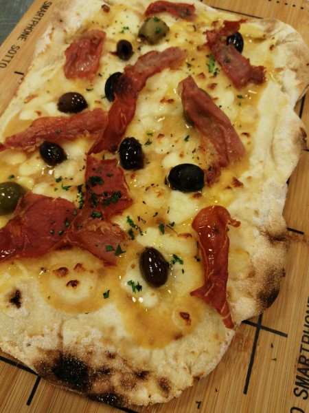 Pizza P.A.L.A. with yellow tomato sauce, buffalo mozzarella, spicy olives and bacon