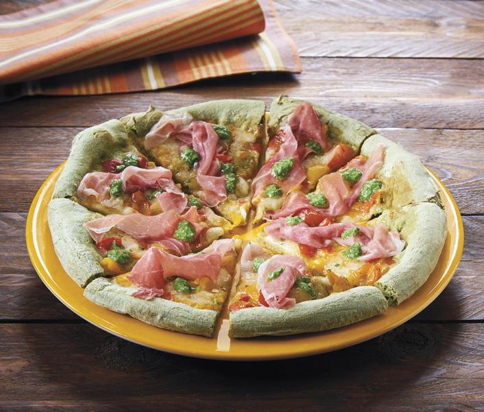 Spinach pizza with peppers, prosciutto and basil pesto