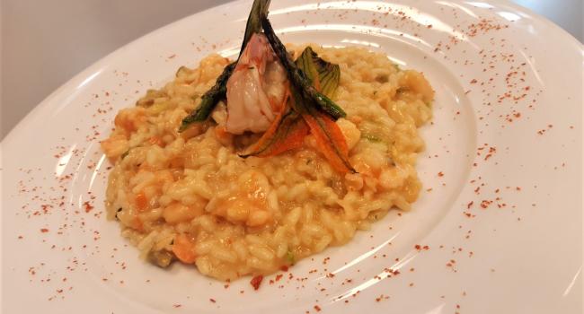 Risotto mit Garnelen, Bisque aus Krustentieren, Spargel und Zucchiniblüten