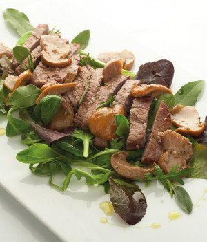 Beef tagliata with porcini mushrooms and mixed salad leaves