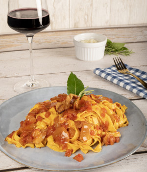 Tagliatelle mit Friggione (Tomaten-Zwiebelsauce) alla Bolognese, Parmesankäse und Speck