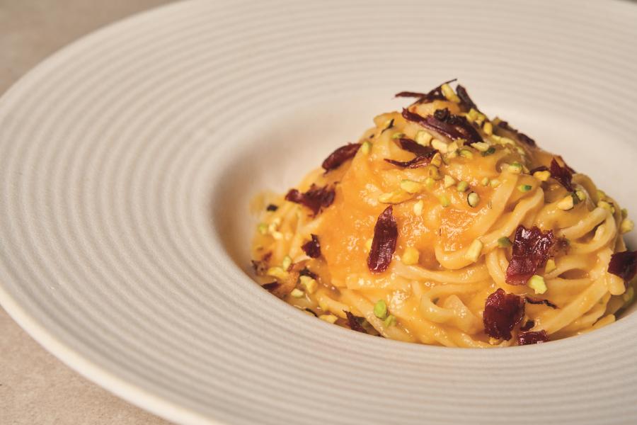 Tagliolini con passata gialla, speck e granella di pistacchio