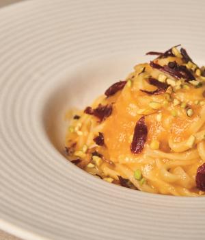 Tagliolini con passata gialla, speck e granella di pistacchio