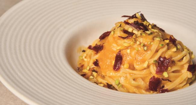 Tagliolini con passata gialla, speck e granella di pistacchio